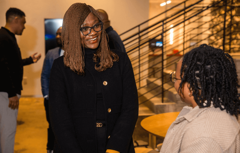 Two Black women in tech talking at event
