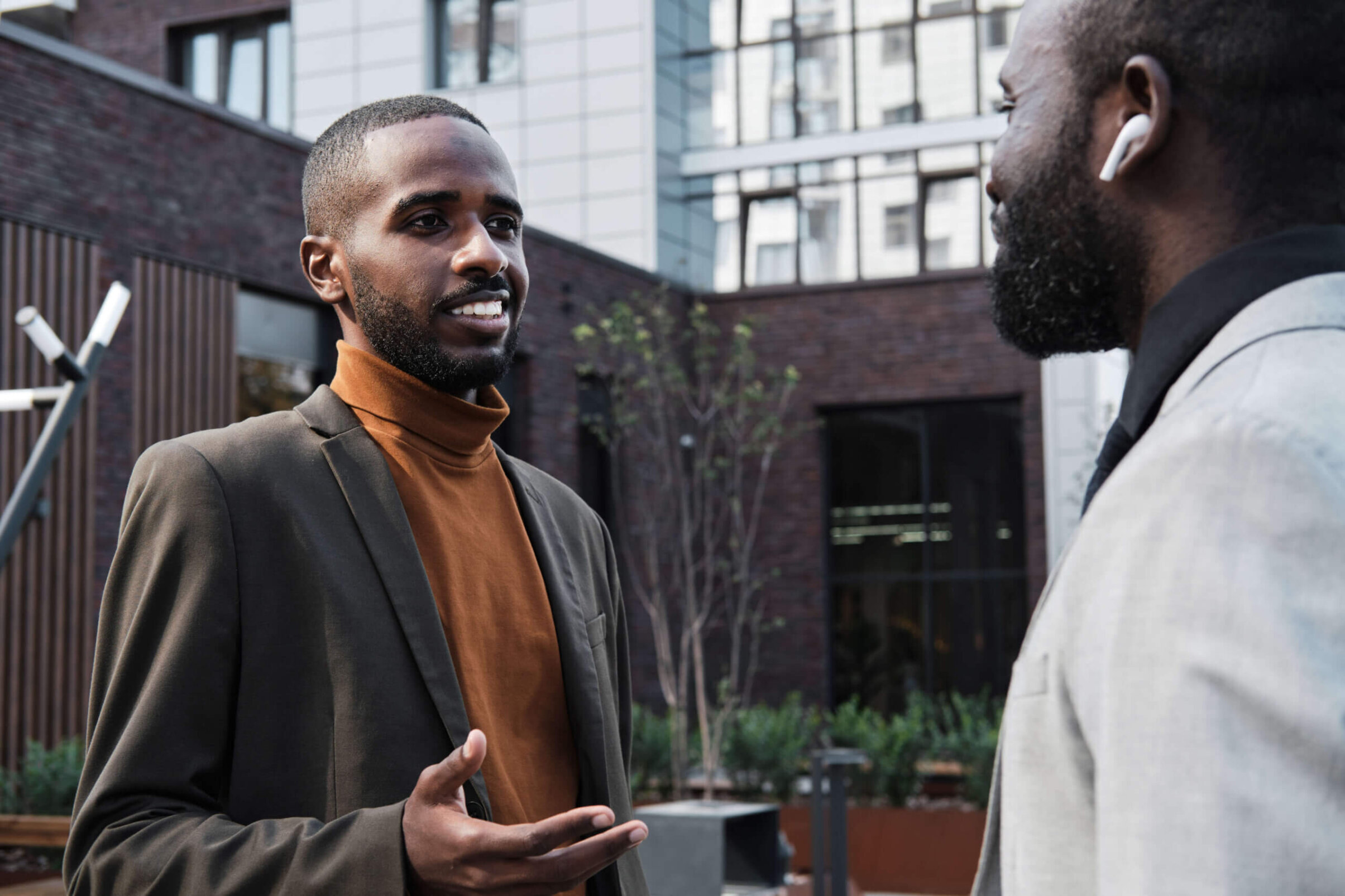 Two Black men talking outside