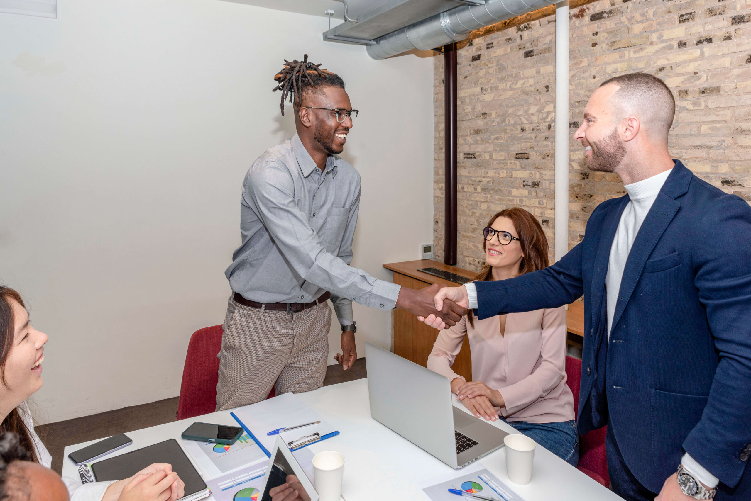 Two business men shaking hands over a table