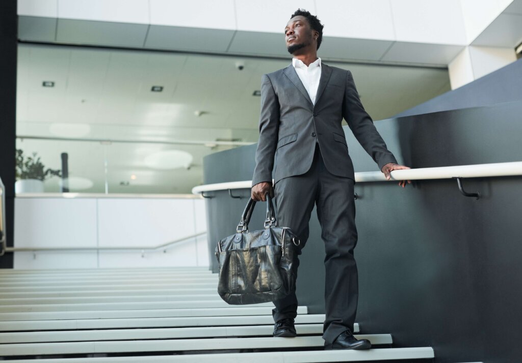Black businessman descending a staircase in an office building